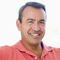 a middle-aged man smiles confidently with his same-day crowns